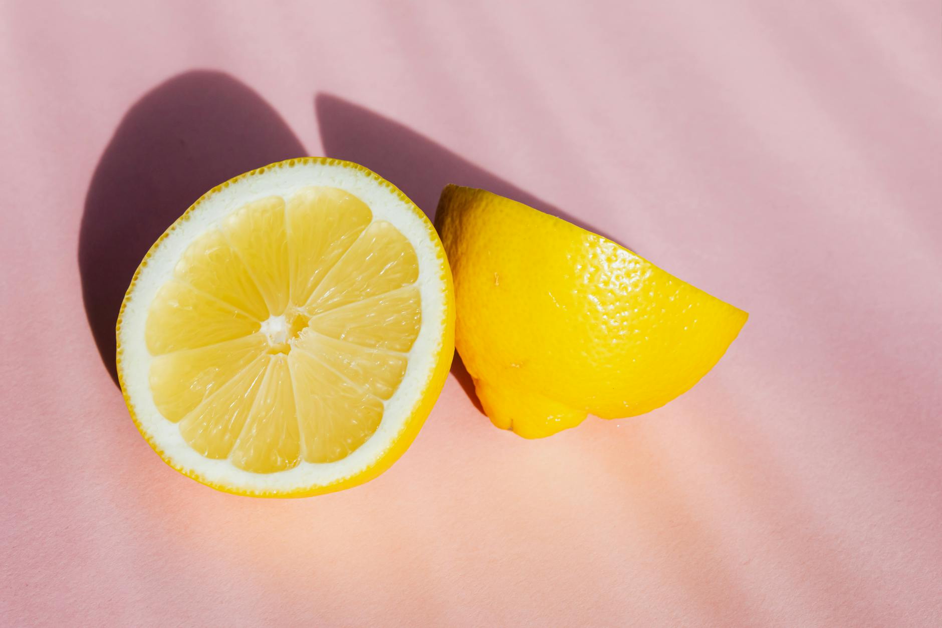 Close-up of a hand holding an orange vibrator against a minimalistic purple backdrop, showcasing modern sensuality.