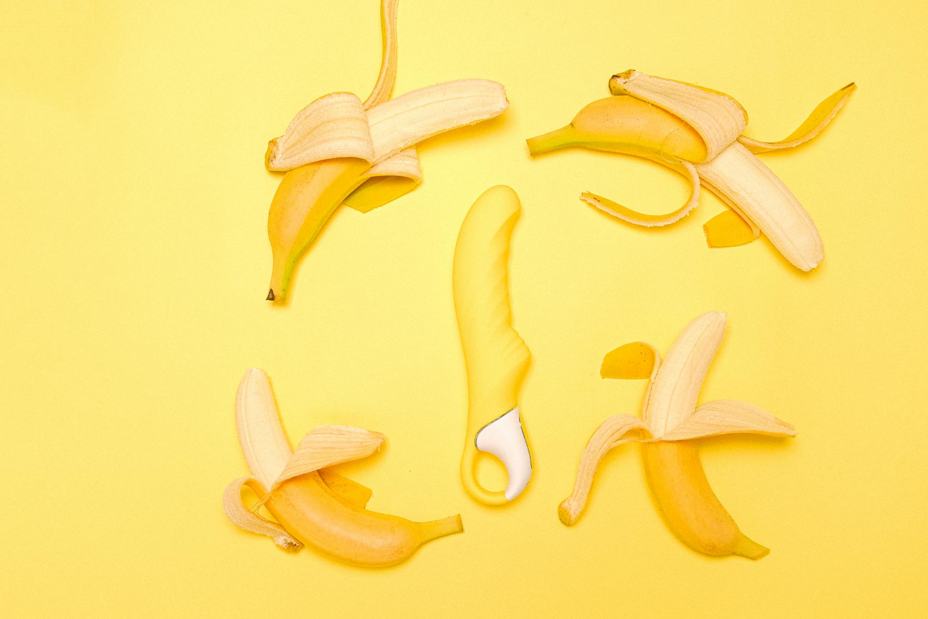 Yellow lemon vibrator surrounded by fresh lemons on a bright background, symbolizing renewed sensation and pleasure.
