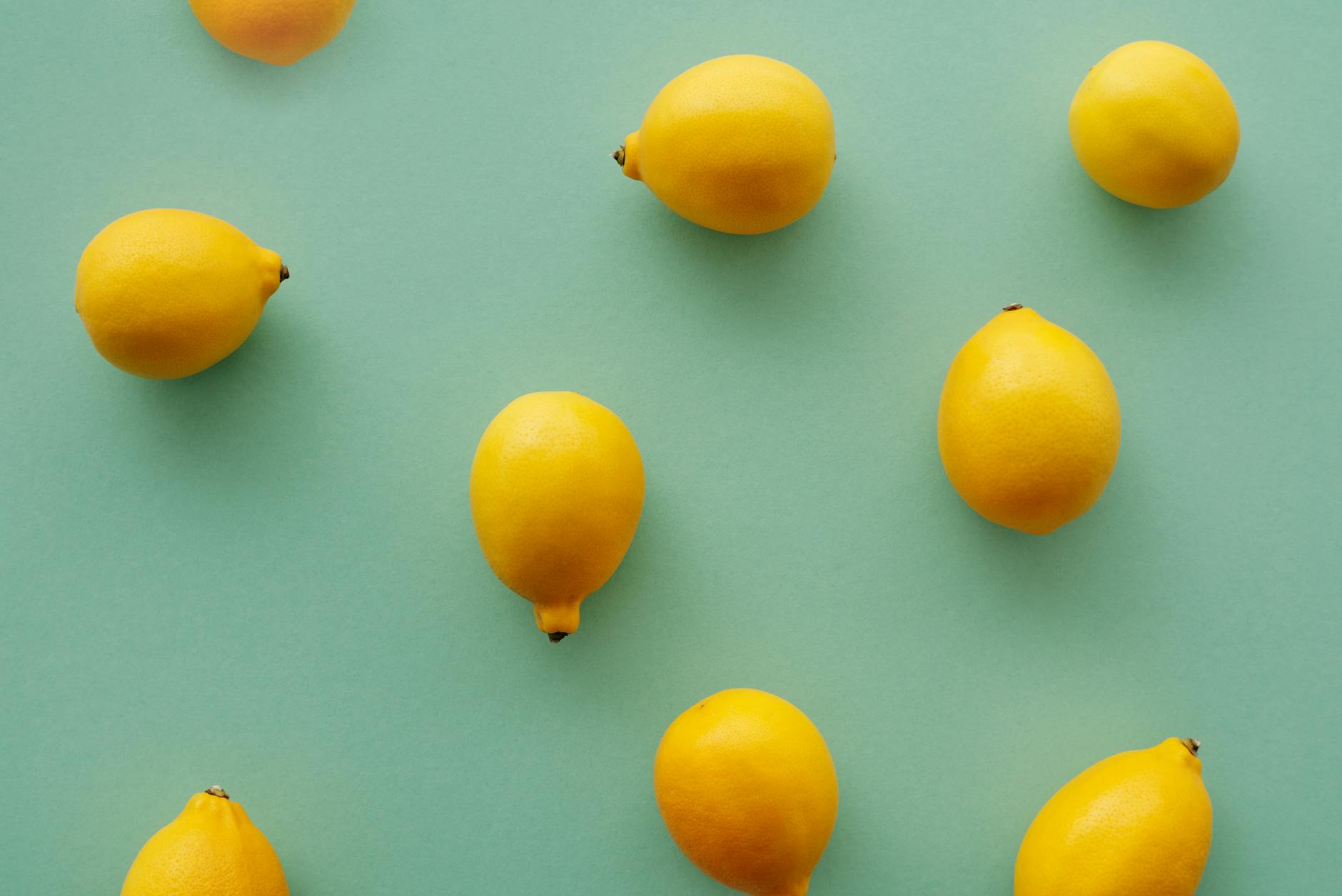 Bright yellow lemons arranged on a pastel green background, symbolizing fresh starts and renewed pleasure